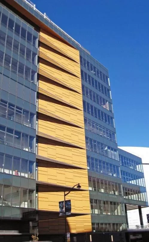 The gray and orange steel and glass facade of the Golden State Warriors Chase Center Towers, a high-rise building in Mission Bay, CA.