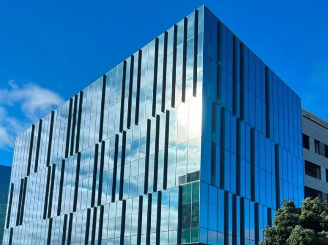 The facade blue reflective glass facade of The Landing Life Sciences, a laboratory / science building in Burlingame, CA.