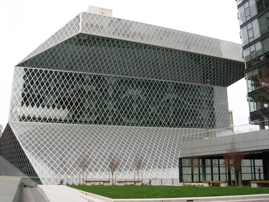 Distant view of the Seattle Central Library showing the gray steel & black glass lozenges of the facade and the geometric angles of the building.