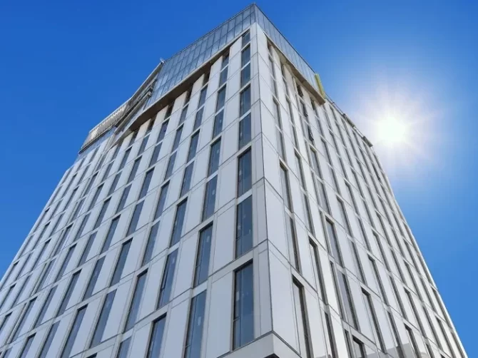 An upwards perspective view of the geometrically angled, gray steel and glass facade of the San Francisco Conservatory of Music.