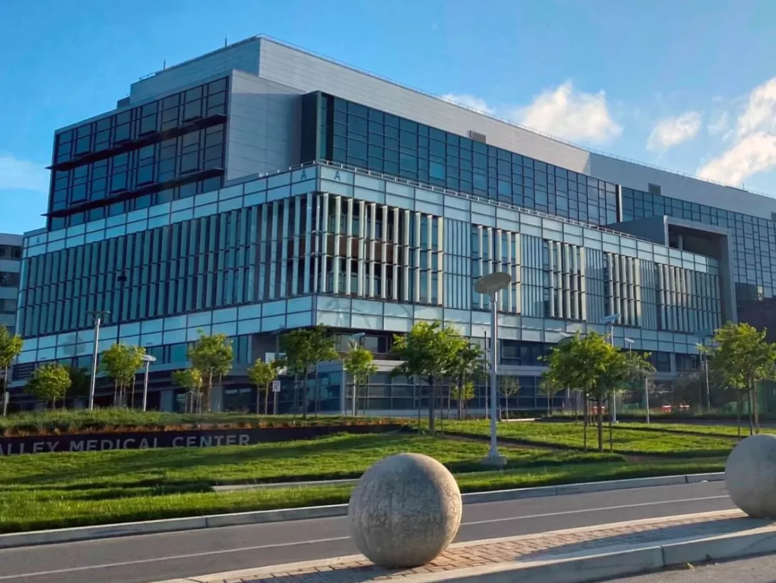 Wide-angle view of the blue glass and white & gray metal facade of the Sobrato Pavilion at the Santa Clara Valley Medical Center.