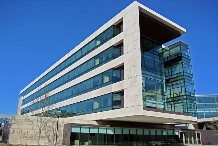 The concrete and green glass Bill & Melinda Gates Foundation HQ building cantilevering out over the road.