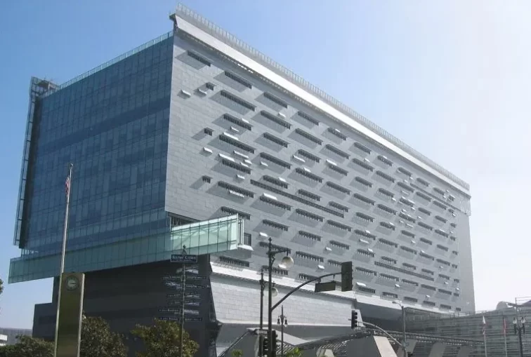 The blue-gray facade of the Caltrans District 7 HQ building in Los Angeles reflecting the sun from the blue California sky.