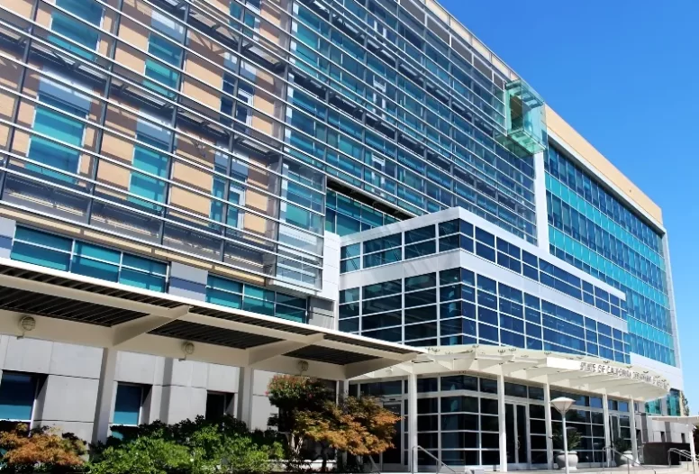 The shading system on the green glass and orange brick facade of the CA DMV HQ in Sacramento, CA.