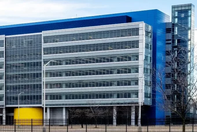 The blue, gray, and yellow glass and steel facade of the General Motors Technical Center in Warren, MI.
