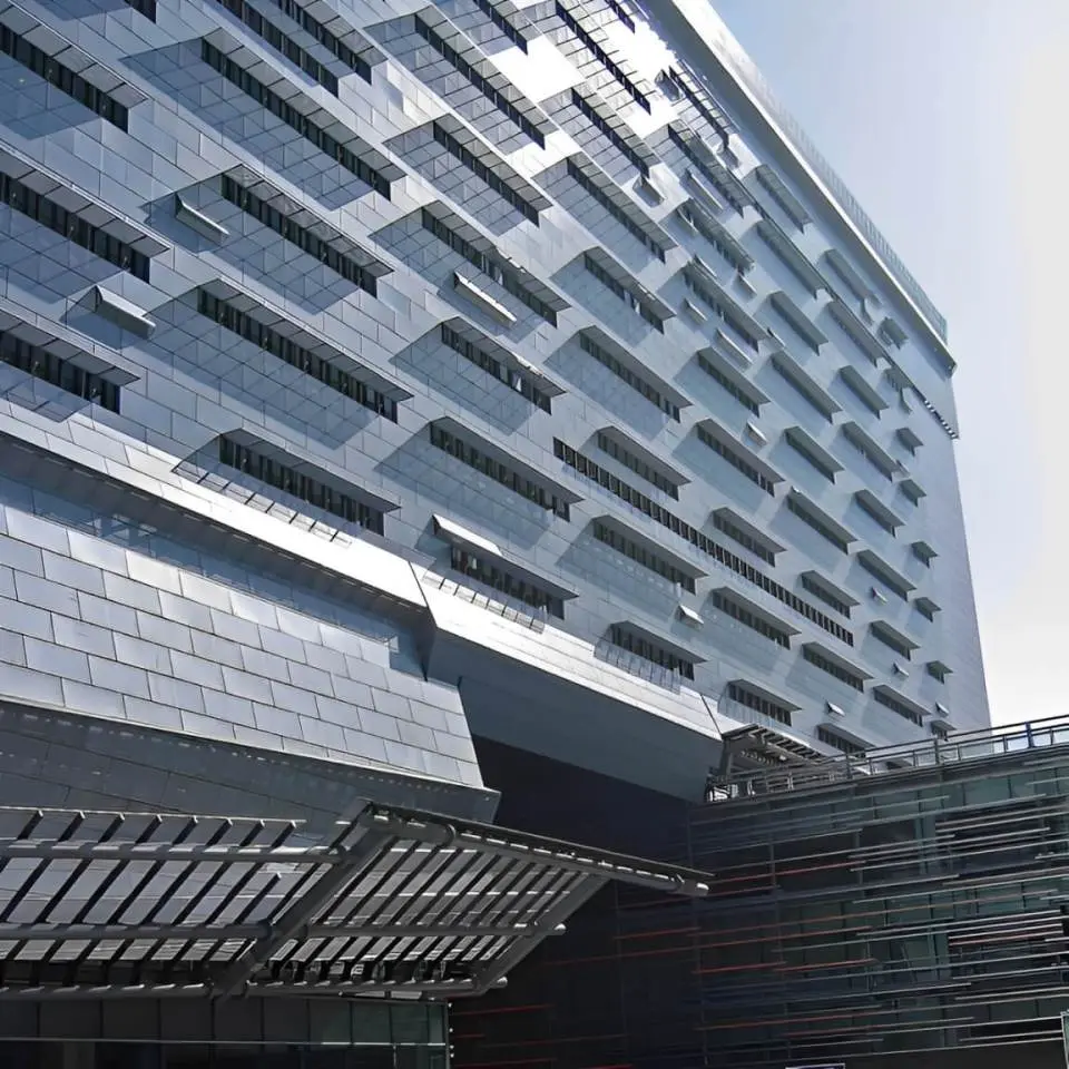 The blue-gray facade of the Caltrans District 7 HQ building in Los Angeles reflecting the sun from the blue California sky.