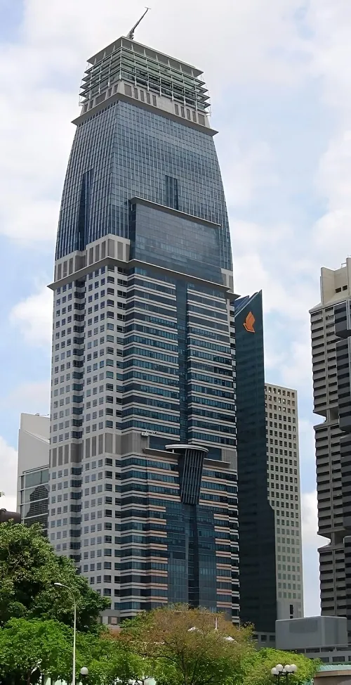 The black and gray steel and stone facade of Capital Tower, a high-rise building in Singapore.