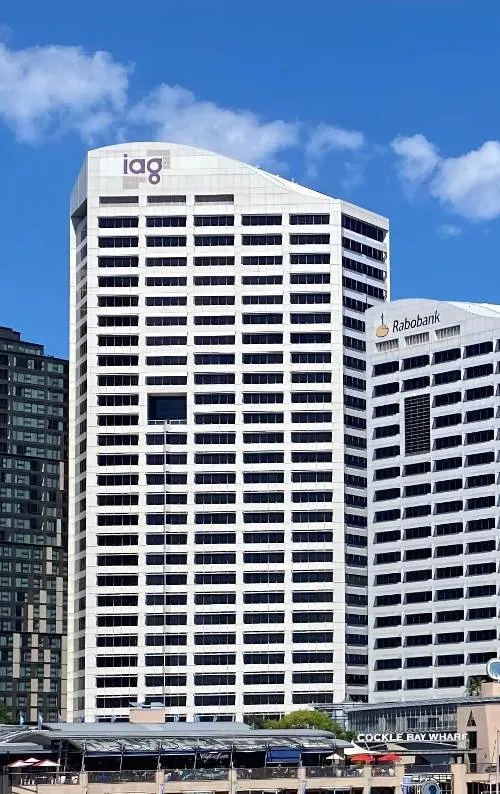 The bright, white facade pierced by dark rectangular windows of the Darling Park Tower II, a high-rise building in Sydney, Australia.