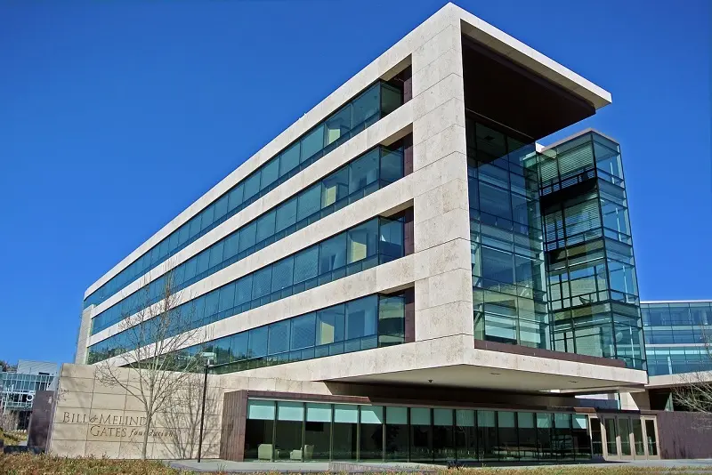The concrete and green glass Bill & Melinda Gates Foundation HQ building cantilevering out over the road.