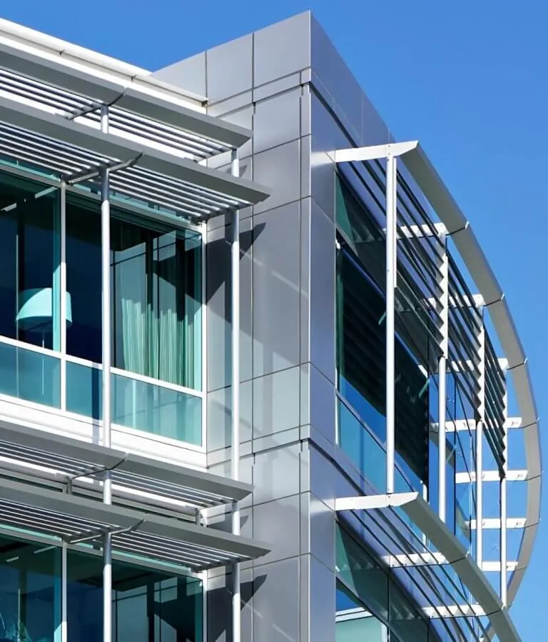 Close-up of the Stanford Outpatient Center in Redwood City, showing the silver & green facade and details of the various shading devices.