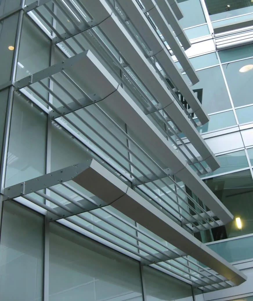 Ground level up view of the facade of the Stanford Outpatient Center in Redwood City, showing the slatted metal horizontal external sun shading system.