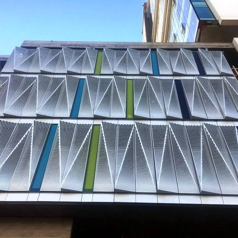 A close-up, abstract view of the blue, green & white facade screen panels on 1700 Webster St. in Oakland, CA.