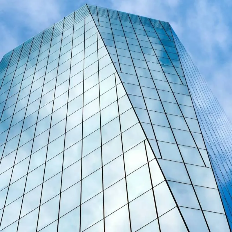 The cloudy blue San Francisco sky reflected in the rectilinear facade of 535 Mission Street.