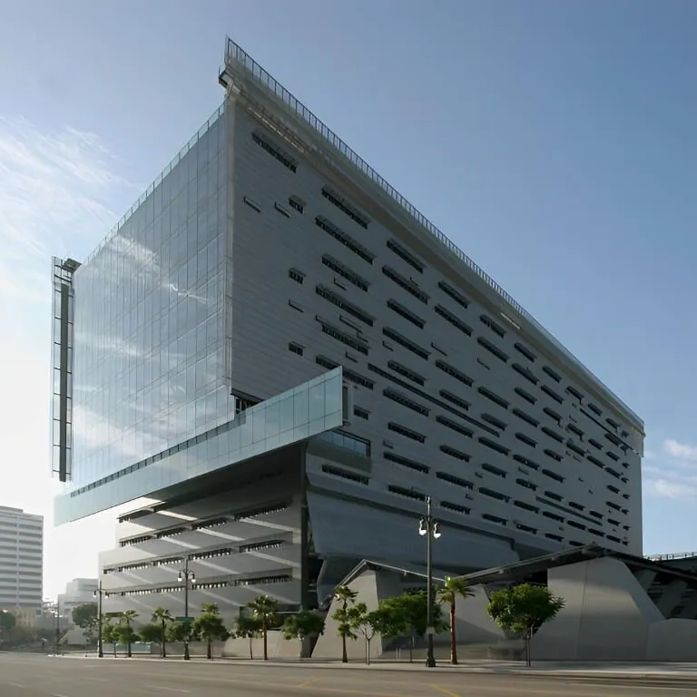 A ground level perspective view of the Caltrans District 7 HQ building in Los Angeles showing the gray steel facade & extensive external shades in the early morning light.