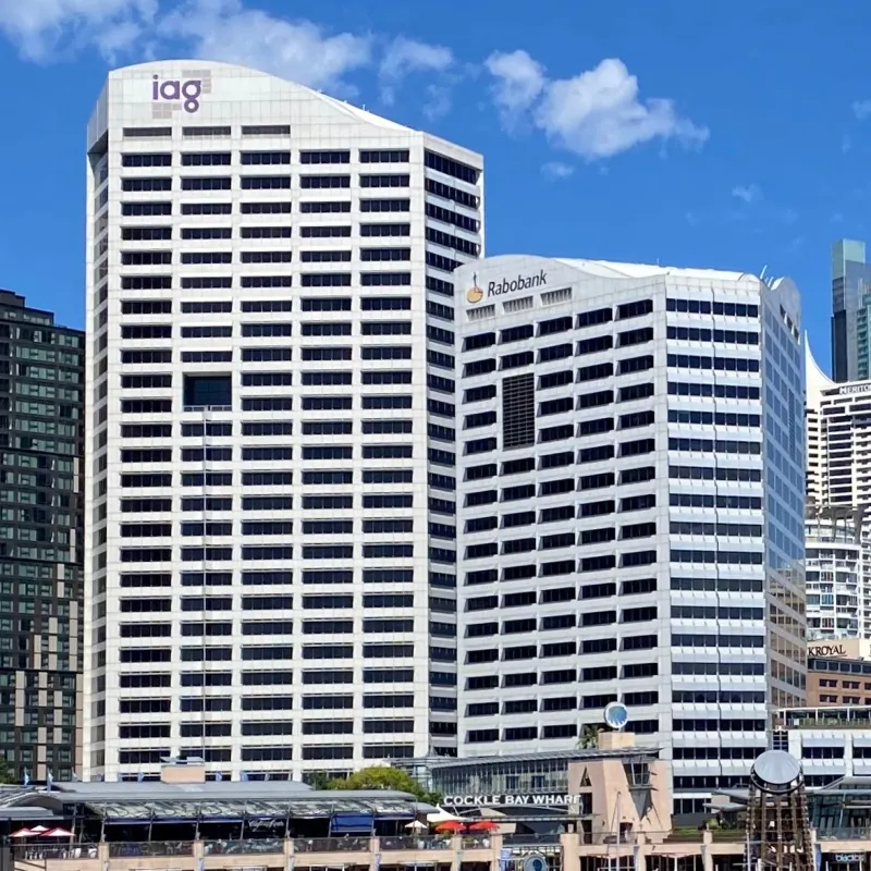 The bright, white facade pierced by dark rectangular windows of the Darling Park Tower II, a high-rise building in Sydney, Australia.