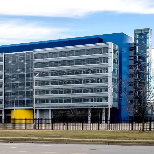 The blue, gray, and yellow glass and steel facade of the General Motors Technical Center in Warren, MI.