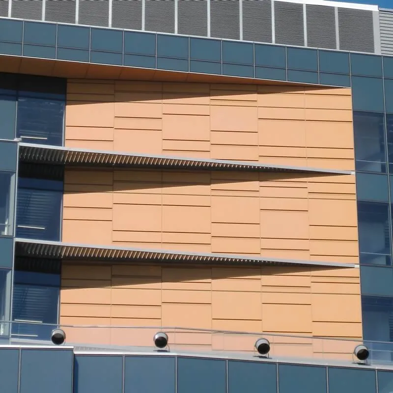 A close up of the orange and gray metal facade of Golden State Warriors & One Hotel Residential in Mission Bay, CA.