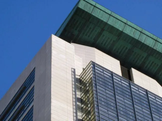 A close-up detail of the top corner of the facade of the Seattle Justice Center.