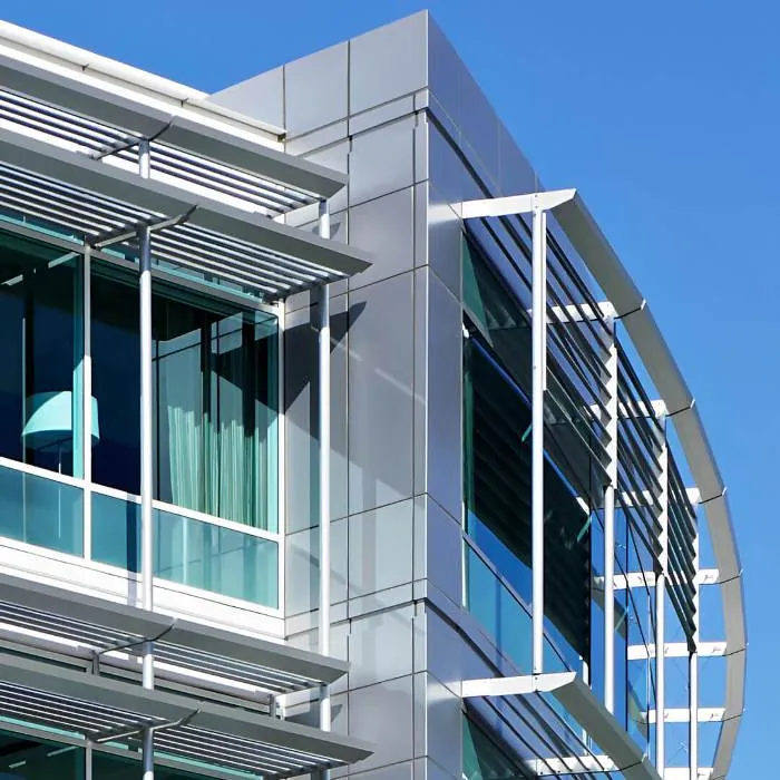 Close-up of the Stanford Outpatient Center in Redwood City, showing the silver & green facade and details of the various shading devices.